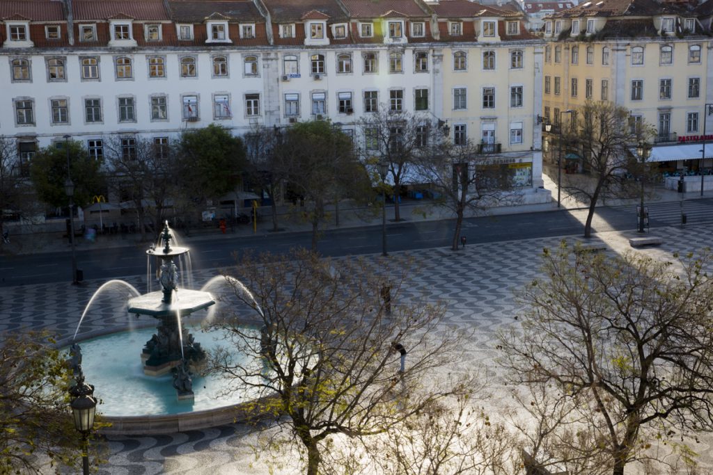 Solens morgonstrålar letar sig in på torget Rossio