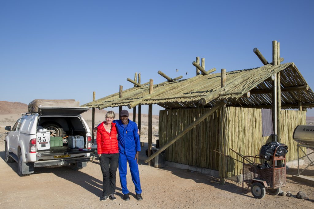 Vi träffar Simon som städar vår campingplats. Efter en trevlig pratstund med honom lämnar vi fina Sossus Oasis Campsite efter två nätter. WC, dusch, diskho,  belysning - allt ryms under vårt tak.