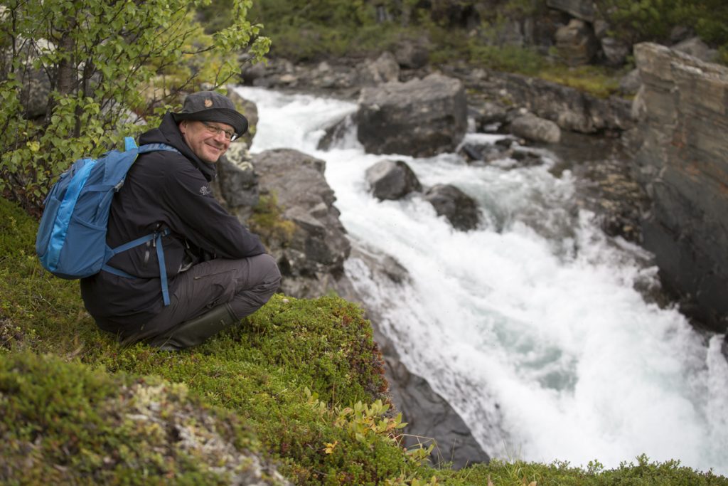 Claes sitter och njuter av att vara där han trivs allra bäst, i naturen. Här vid Kårsafallen.