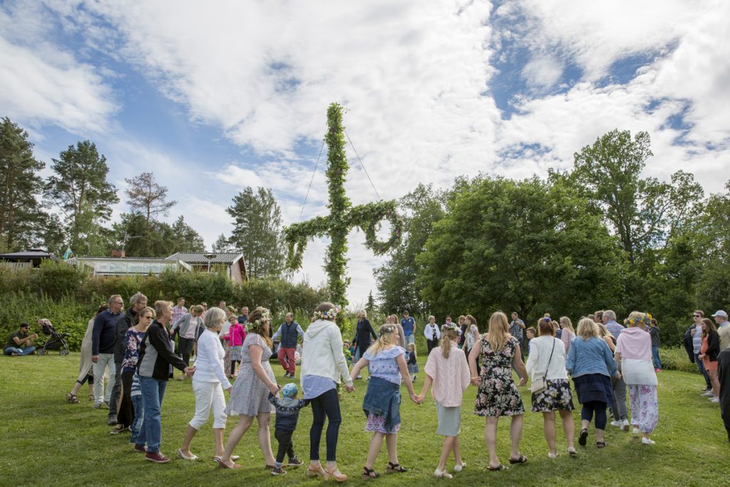 Klassiska svensk tradition med dans runt midsommarstången